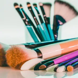 Czarny eyeliner w pisaku leżący na marmurowym blacie obok lusterka, przygotowany do wykonania makijażu kreski na powiece.