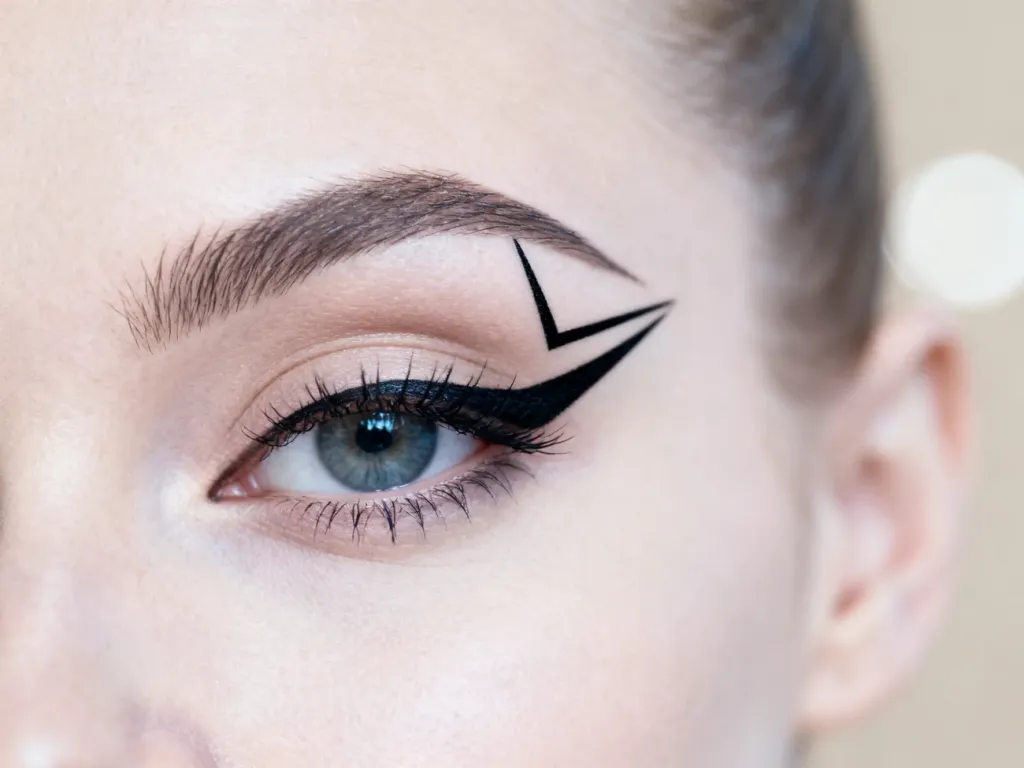 Precyzyjna, czarna kreska typu graphic eyeliner na powiece, tworząca nowoczesny i geometryczny wzór.