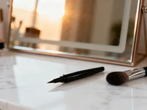 Elegancka kompozycja z różnymi rodzajami korektorów i pędzlem na marmurowym blacie, gotowa do testowania produktów.
